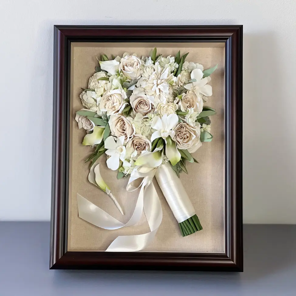 Cream and blush wedding bouquet in dark wood shadow box